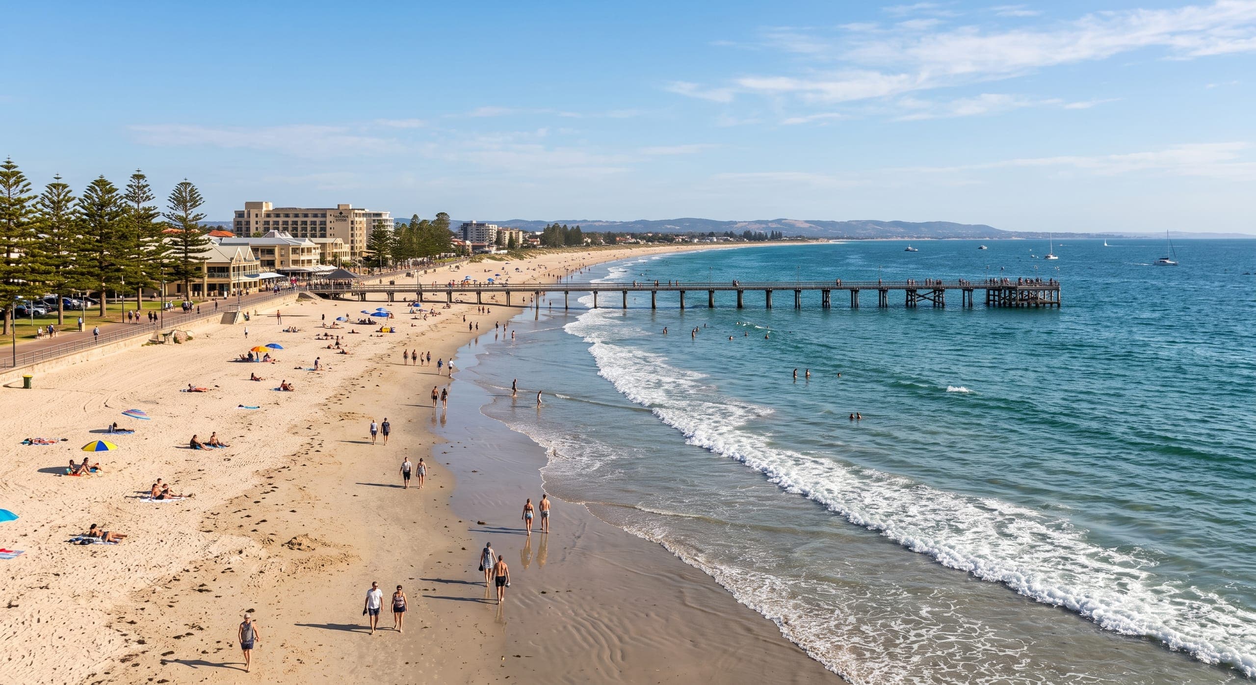 An Adelaide beach on a clear afternoon, with a long jetty running out into calm blue water
